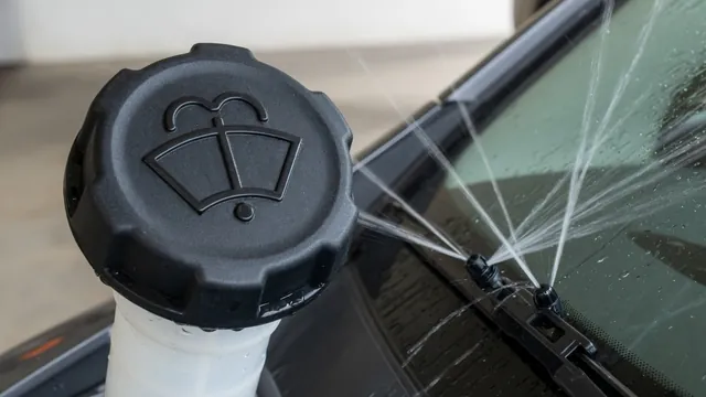 Illustration of a windshield washer fluid warning symbol and a labeled washer fluid reservoir cap