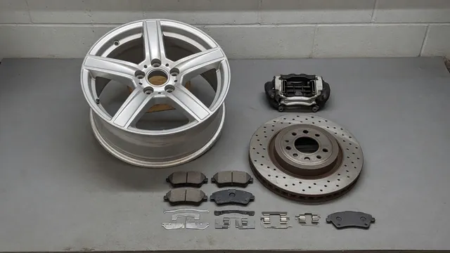 Illustration of a brake rotor, pads, caliper, and shims beside a car wheel