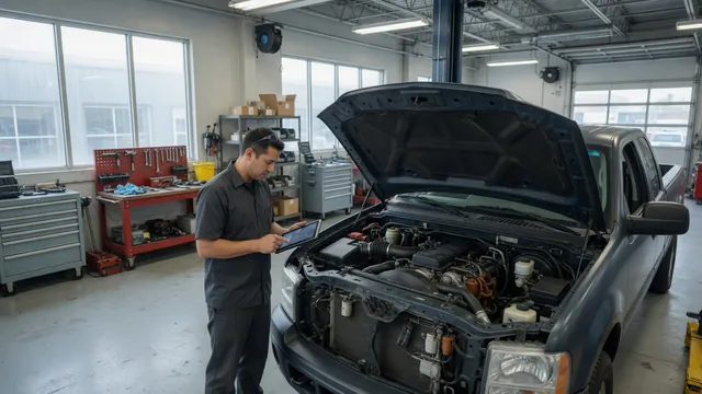 Technician checking diagnostic data beside a diesel vehicle with its hood open