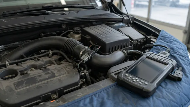 Intake air temperature sensor connector near an engine air intake with a diagnostic scanner nearby