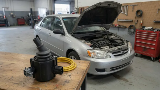 Ignition coil beside a Toyota Camry with its hood open in a repair shop