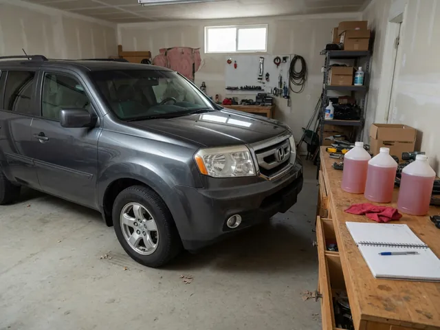 Honda Pilot parked on a level garage floor with sealed transmission fluid containers on a nearby workbench